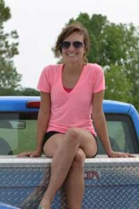 Photo: Hallie Thompson sitting on a pick-up truck